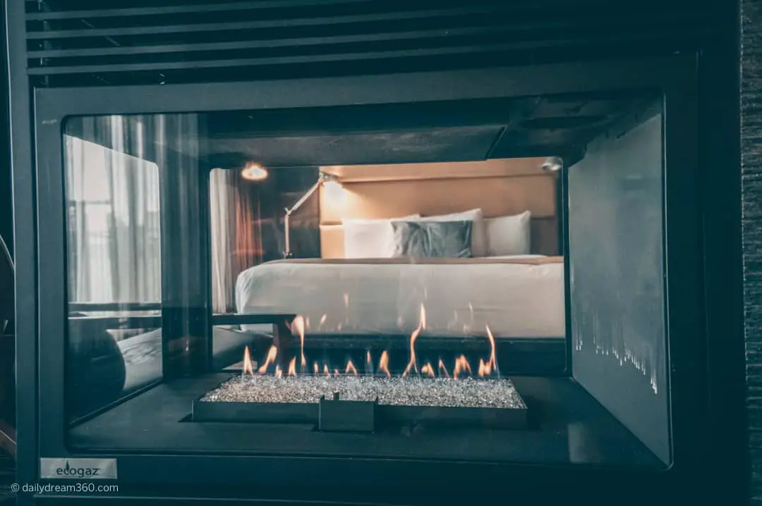 look through the fireplace at the bed in Esterel resort and Spa suite