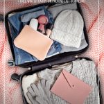 Winter clothing in suitcase on pink bedspread with text How to Pack Light for Winter Travel with This Winter Clothing ListHow to Pack Light for Winter Travel with This Winter Clothing List. (pin image)