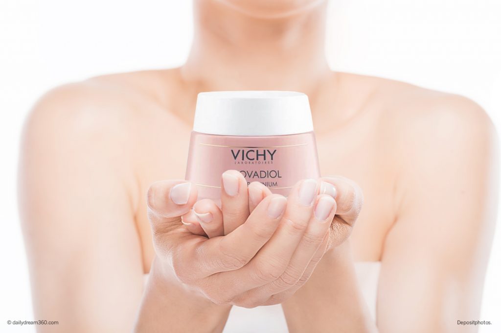 Mature woman holding bottle of Vichy Neovadiol cream