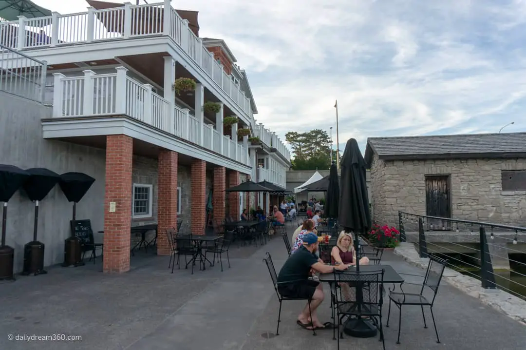 View of building from bar level with tables and chairs along creek. Farmer's Creekside Tavern Leroy
