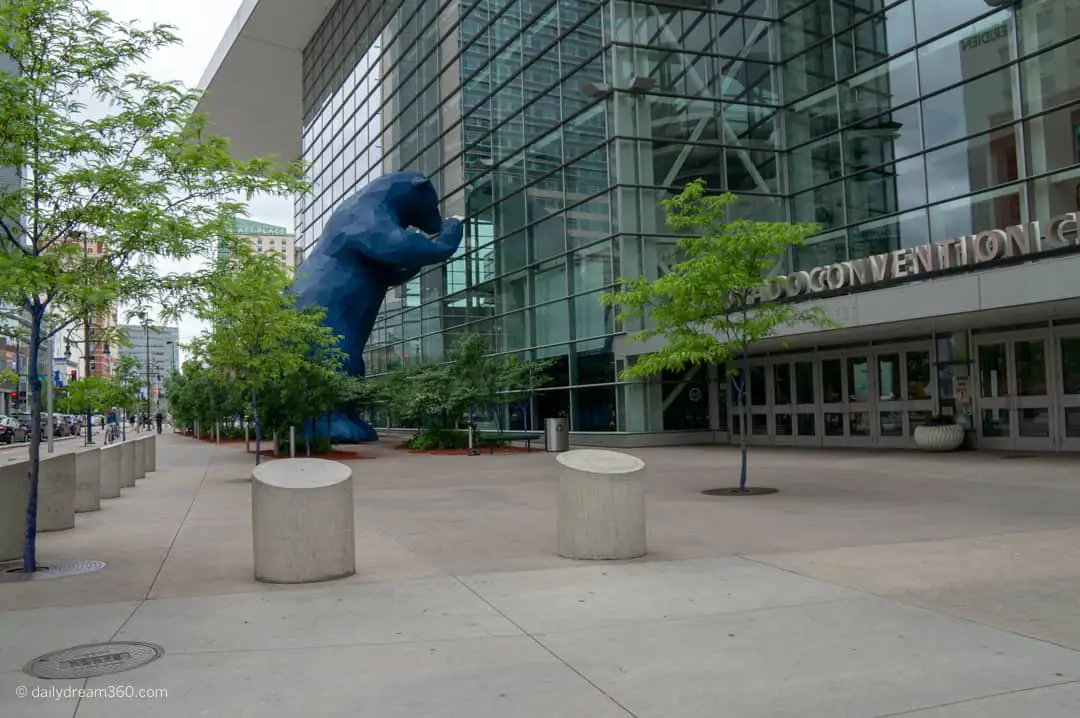 Big blue bear looking into convention center window Denver