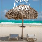 Follow your dreams text with beach chairs and straw beach umbrella in front of ocean on beach