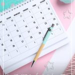 Calendar on pink desk background and text: How to Set Goals and Achieve Them with Free Goal Tracking Worksheet