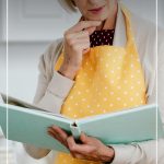 Woman holding cookbook with text How to Detox Sugar with the Best Books on Quitting Sugar (pin image)