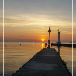 Sunset on dock in Grand Bend Ontario with text: Destinations for Summer Road Trips in Ontario