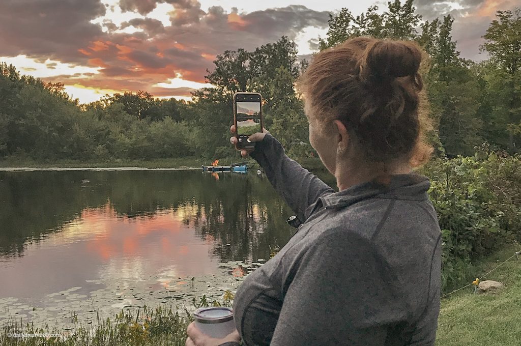 Sharon taking photo of sunset by the lake