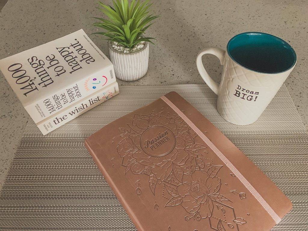 Passion Planner on counter with coffee cup and books