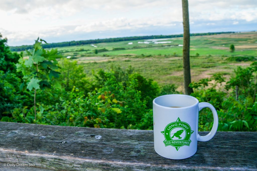 Coffee on wood rail during hike at Long Point Eco-Adventures