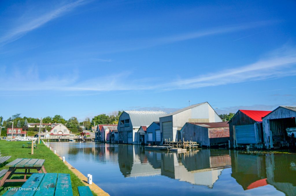 Boat houses reflecting on the water in Port Rowan Ontario