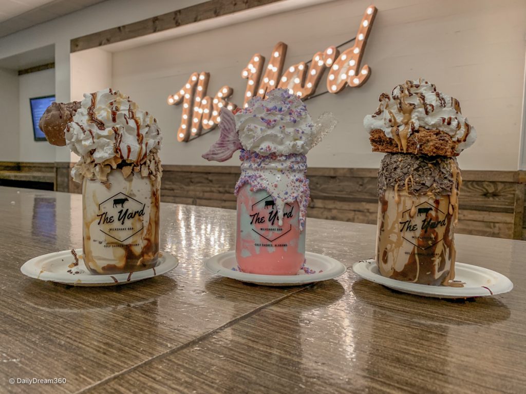 3 milkshakes lined up with lighted sign at Yard Milkshake Bar Gulf Shores