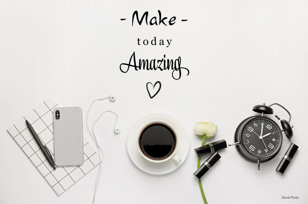 desktop with phone, keyboard, coffee and alarm clock and words make today amazing