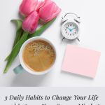 White desktop with coffee flowers alarm clock and pink post it notepad. Pin Text: 3 Daily Habits to Change Your Life and Improve Your Success Mindset