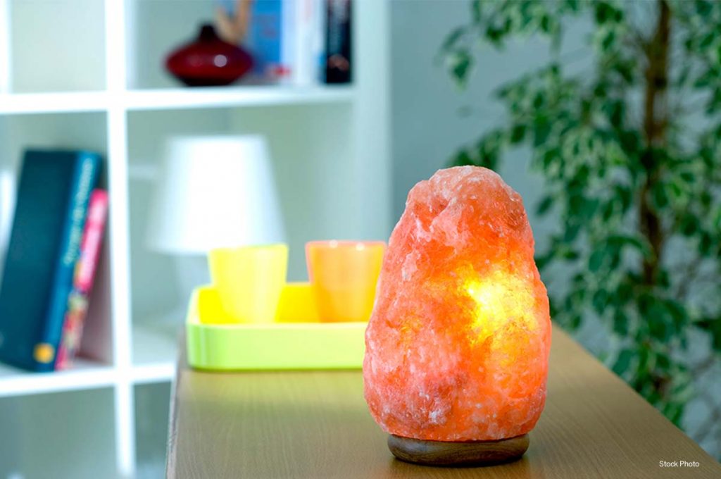 Salt therapy lamp on table with bookcase in background