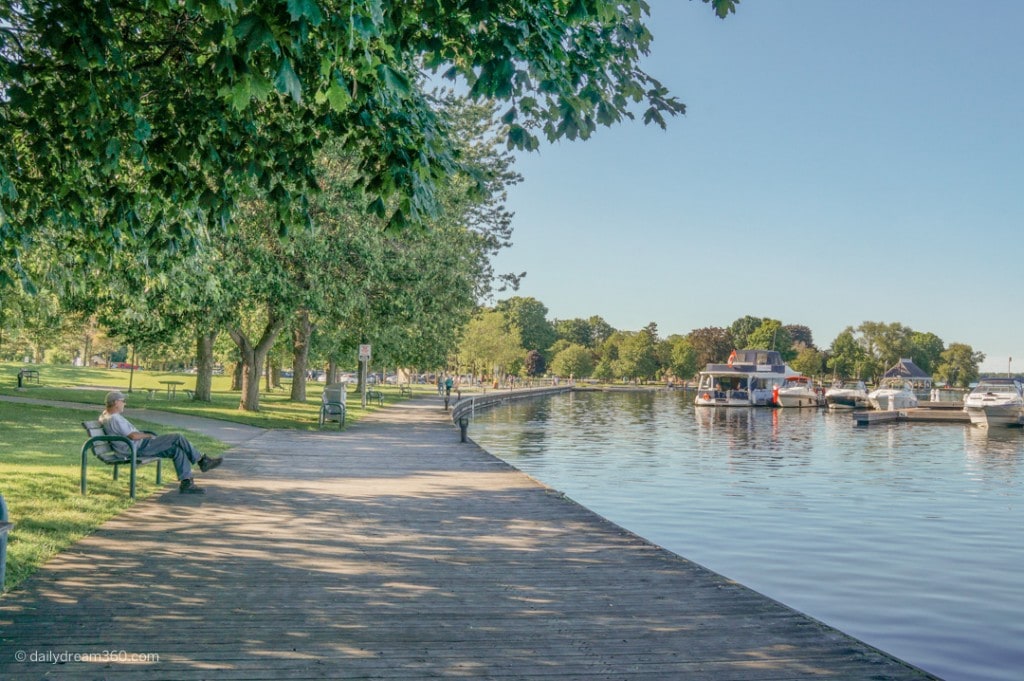 man sitting on bench in front of boardwalk at Orillia Ontario waterfront