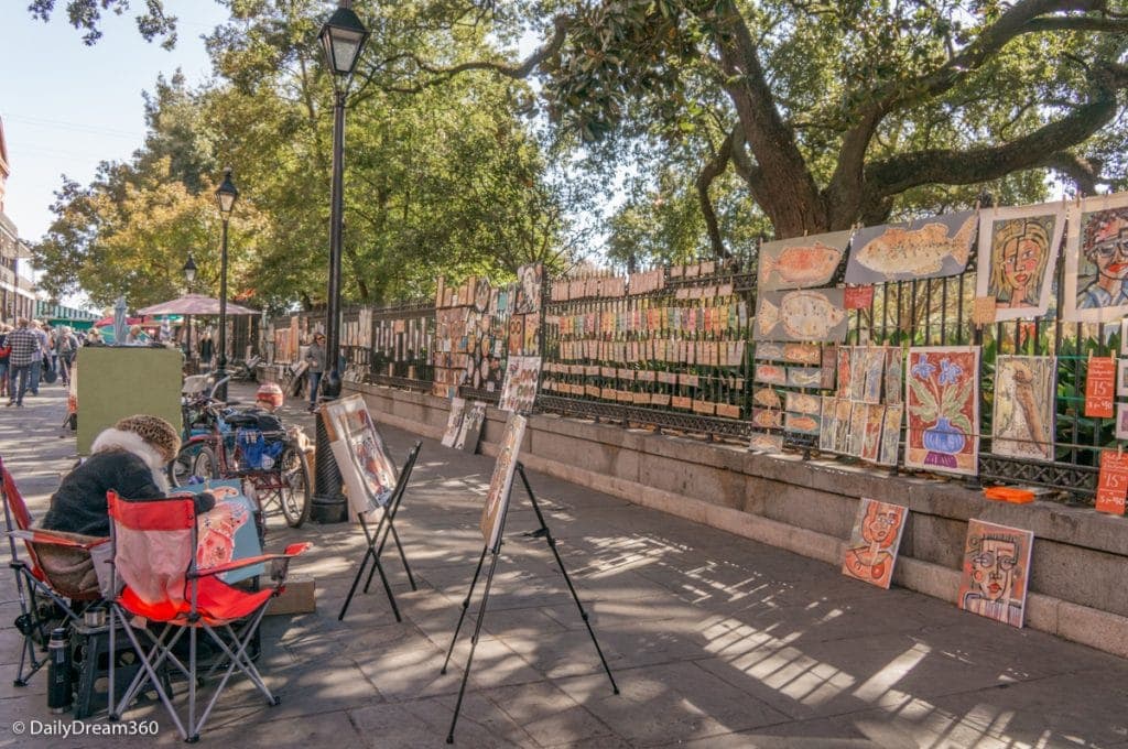 artists in Jackson Square New Orleans with art hanging on wall