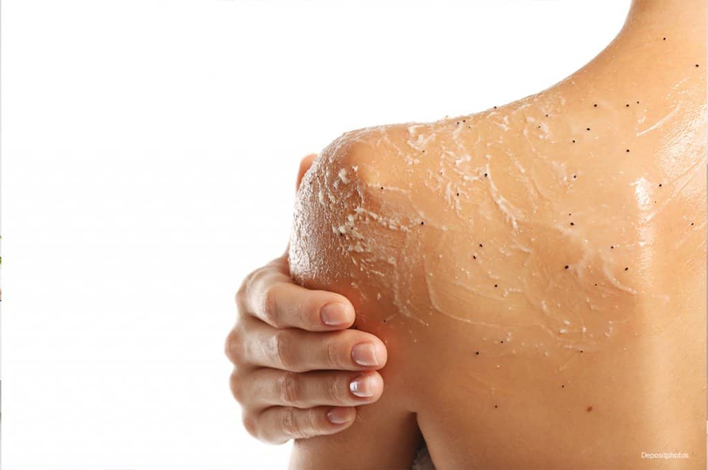 Women applying body scrub to shoulder