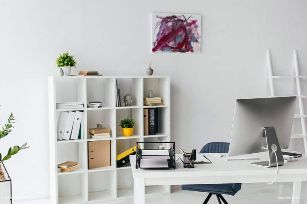 White office desk and bookcase behind it