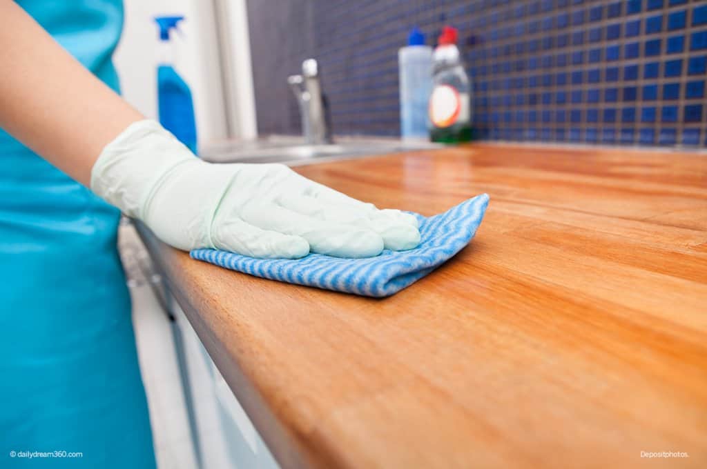 Woman cleaning wood countertop