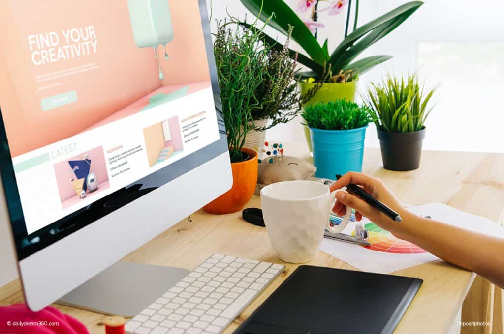 Graphic designer working at computer with coffee