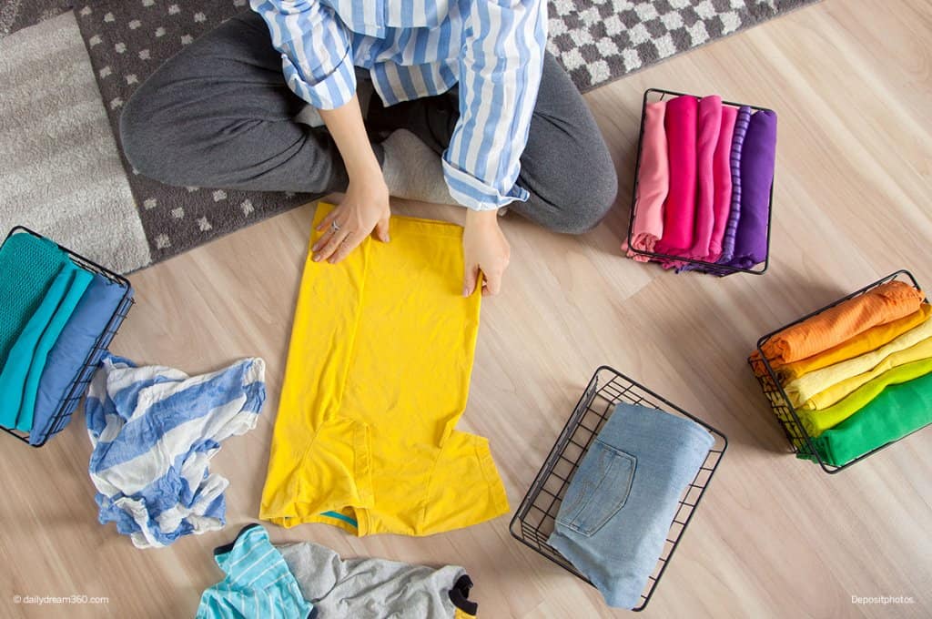 girl folding clothing 7-Day Declutter Challenge: Day 3 How to Declutter Bedrooms