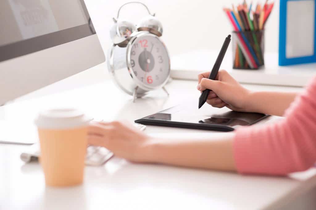women working at desk with tablet