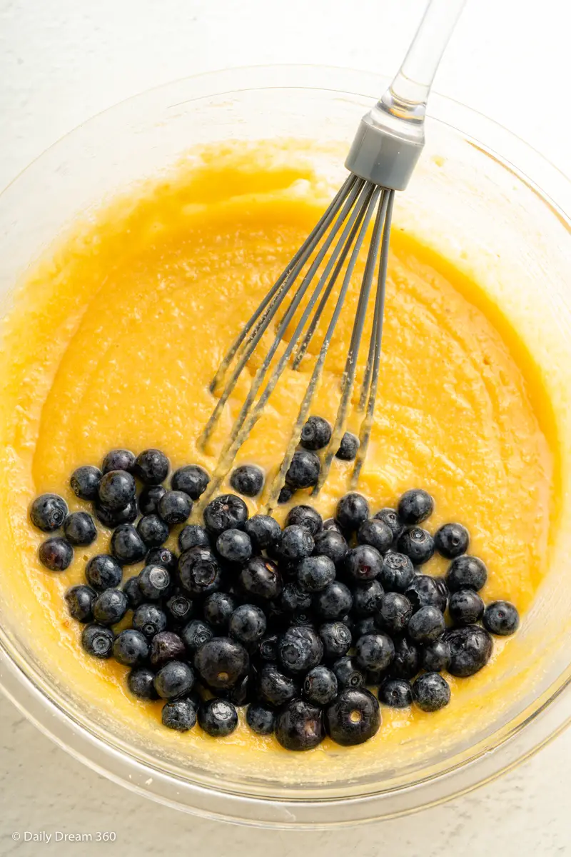 blueberries in bowl with mixture for keto blueberry lemon cake