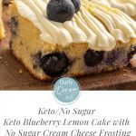 Close up of Keto Blueberry Lemon Cake square with No Sugar Cream Cheese Frosting on wood board
