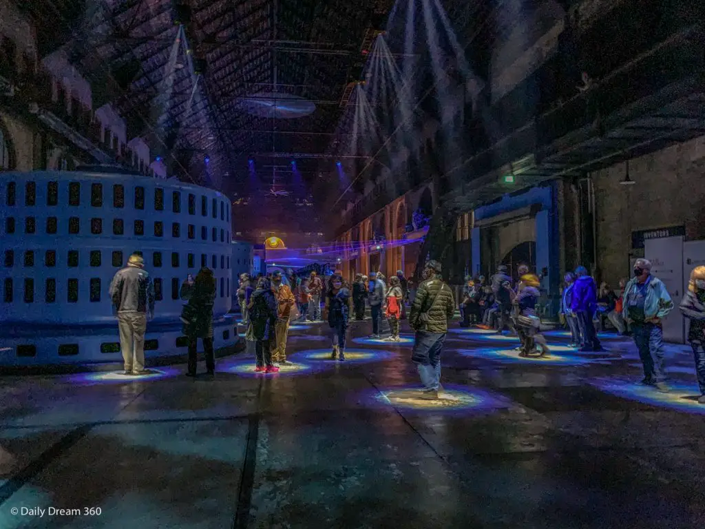 People with lights beneath them at Currents light show Niagara Power Station