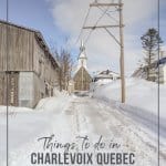 Church and wood buildings on a snowy road in Charlevoix Quebec
