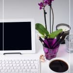 Computer on desk with keyboard and purple flower with text Tips for Working from Home as a Freelancer