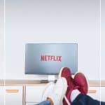 Couple watching Netflix with text List of Travel Inspiration Movies That Will Inspire You to Travel