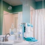 Clean bathroom with green walls and text 7-Day Declutter Challenge: Day 4 Cleaning and Organizing Bathrooms