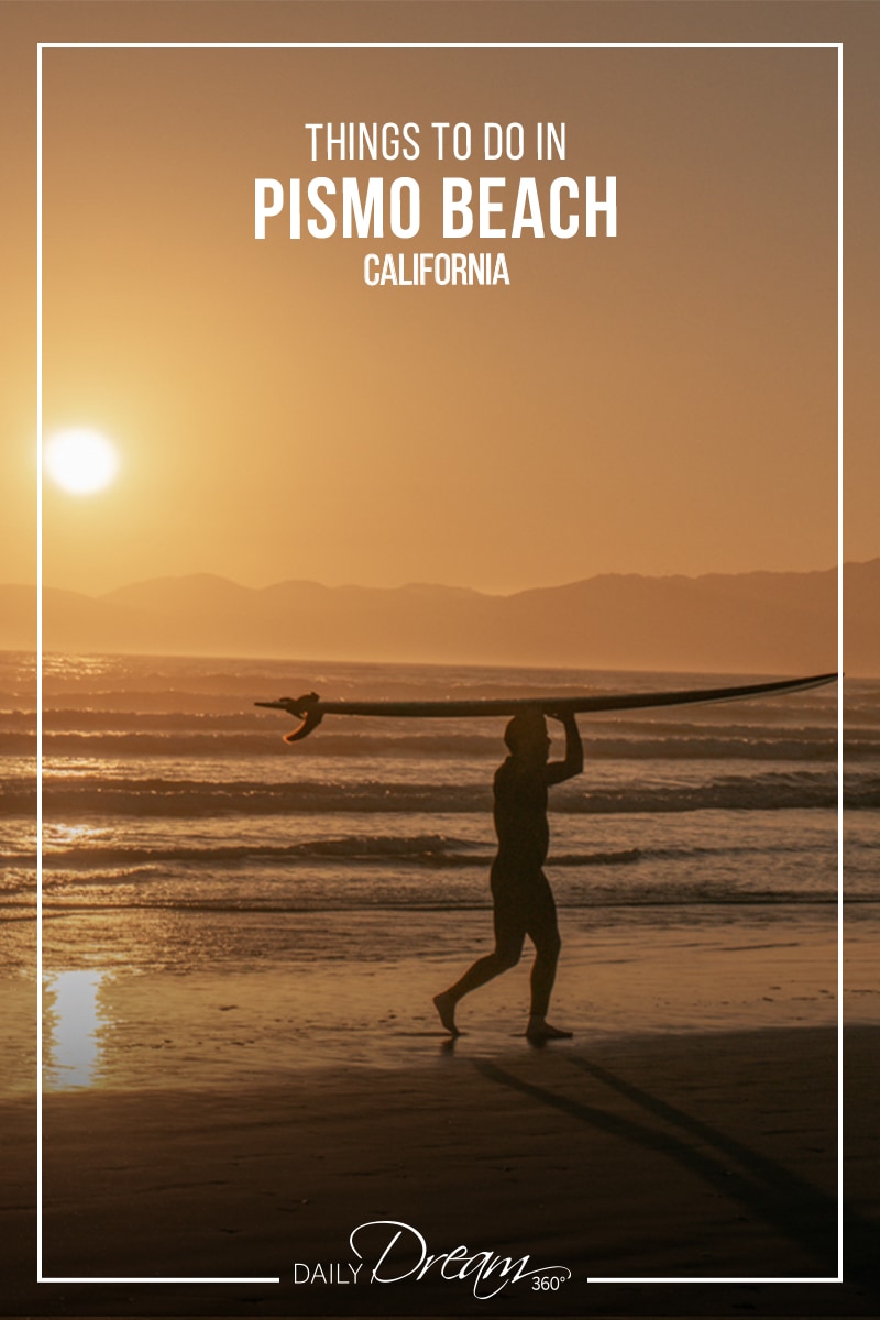 Surfer walks as sunsets behind him at Oceano Dunes Beach CA