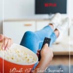 girl with popcorn watching tv with text List of Travel Inspiration Movies That Will Inspire You to Travel