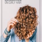 Girl applying oil to hair with pin text How to Use MoroccanOil on Curly Hair