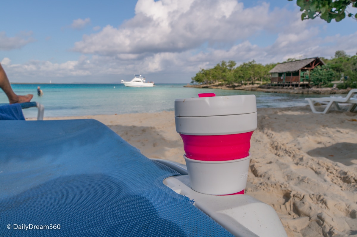 stojo cup inside cup holder of sun chair on beach